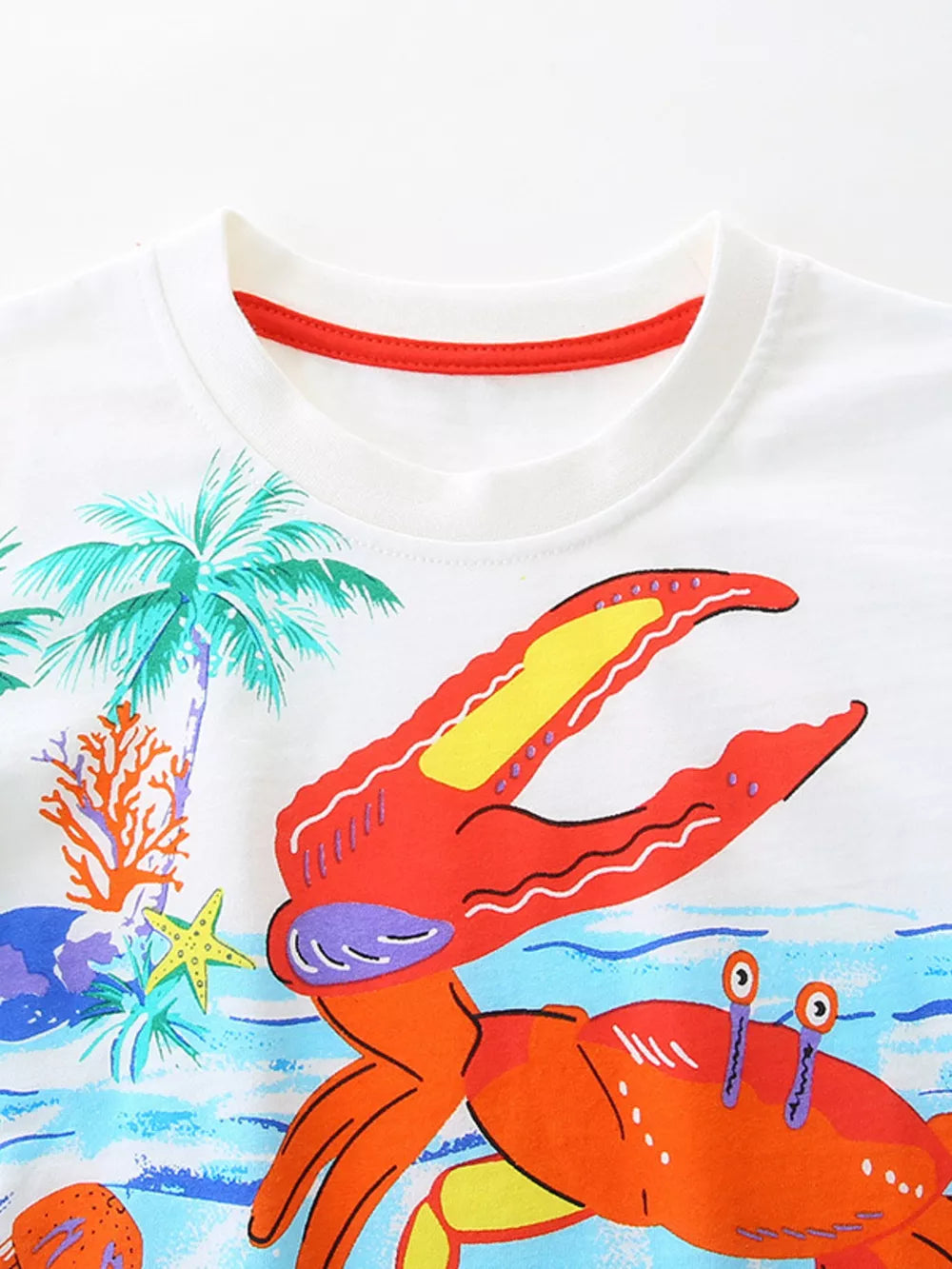 White cotton crew neck t-shirt with colorful crab and tropical scene graphic.