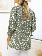 Green animal print blouse with smocked half sleeves and puff shoulders.