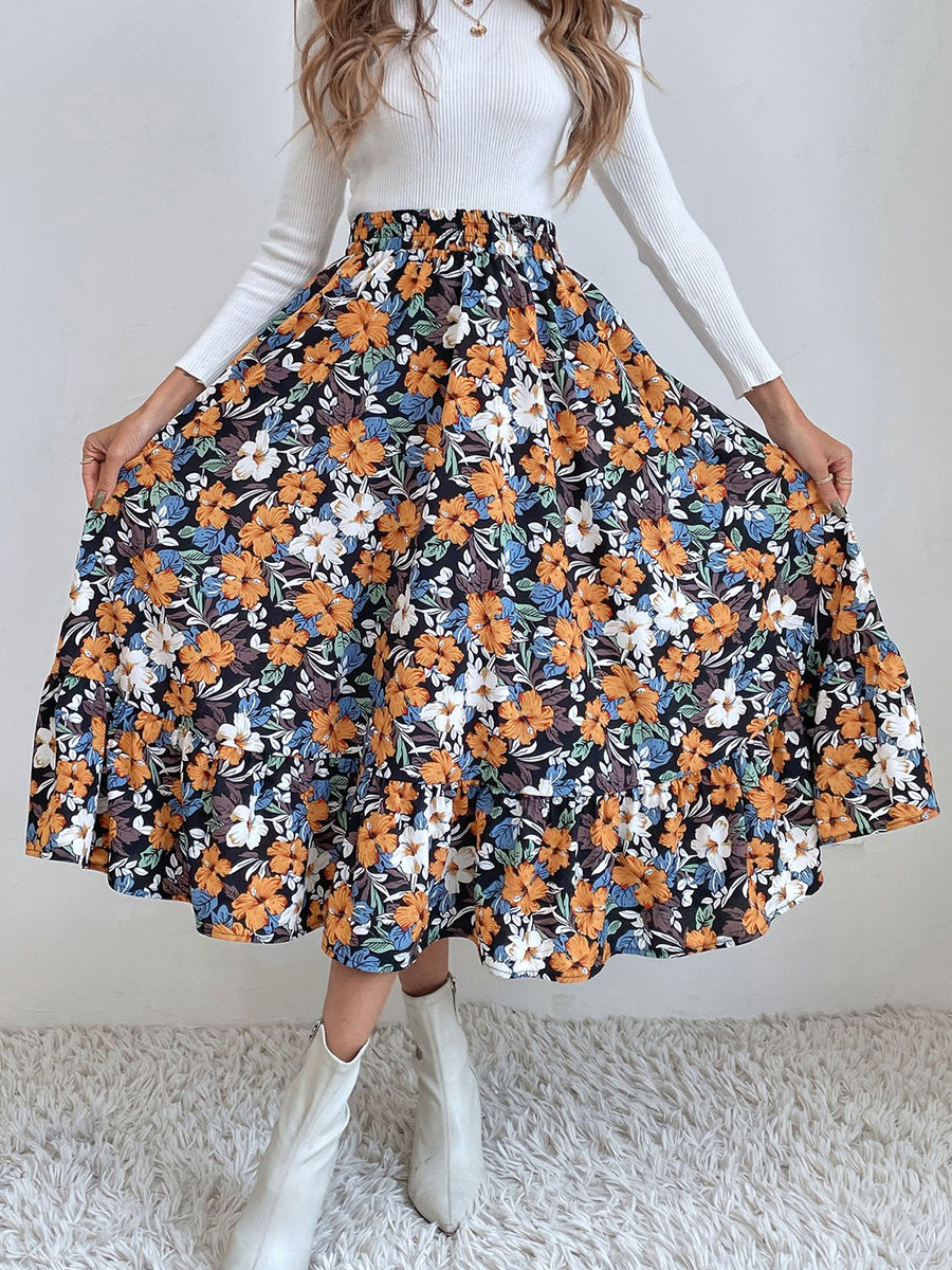 Tiered midi skirt with a black floral print, elastic waist, and ruffled hem.