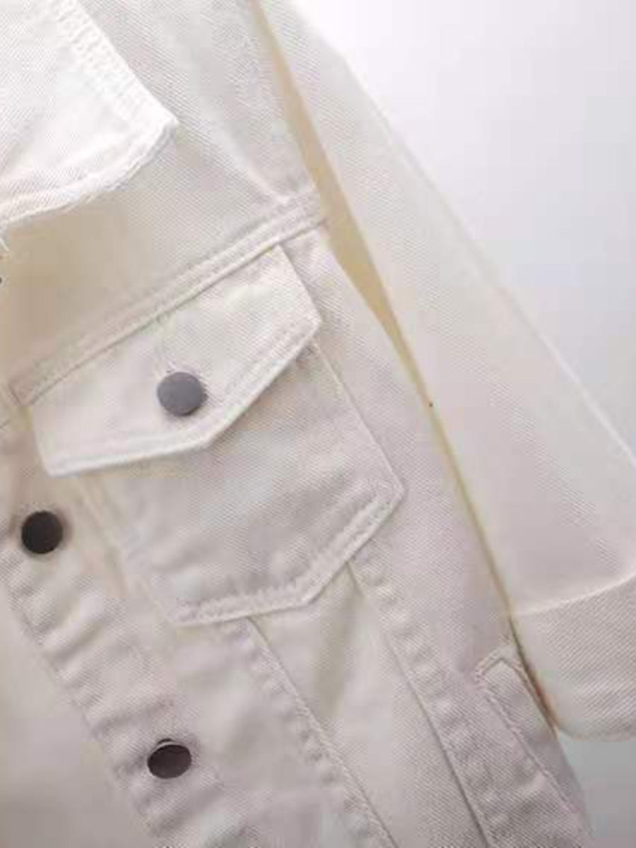 White denim trucker jacket with button-flap chest pockets and button front detail.