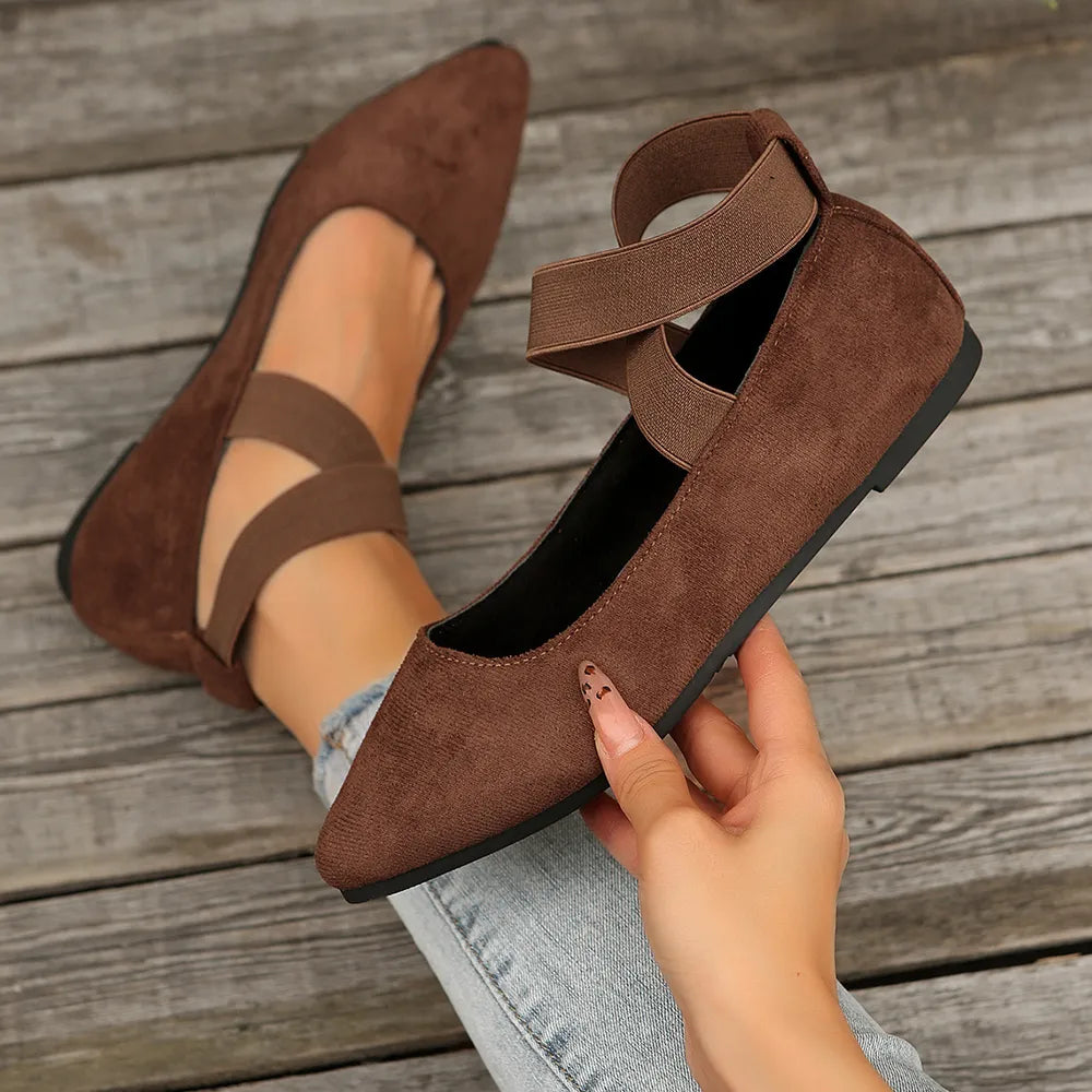 Dark brown suede crisscross strap pointed-toe ballet flats with elastic ankle straps.