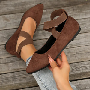 Dark brown suede crisscross strap pointed-toe ballet flats with elastic ankle straps.
