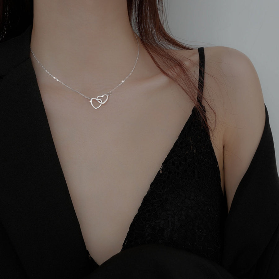 Silver interlocking heart pendant necklace on a delicate chain.