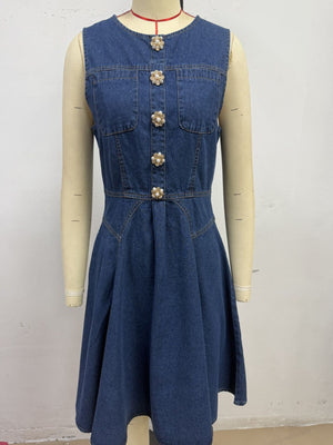 Denim A-line dress with decorative pearl buttons and chest pockets.
