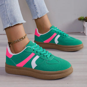 Chic lace-up sneakers in green with pink and white contrast stripes and a brown sole.