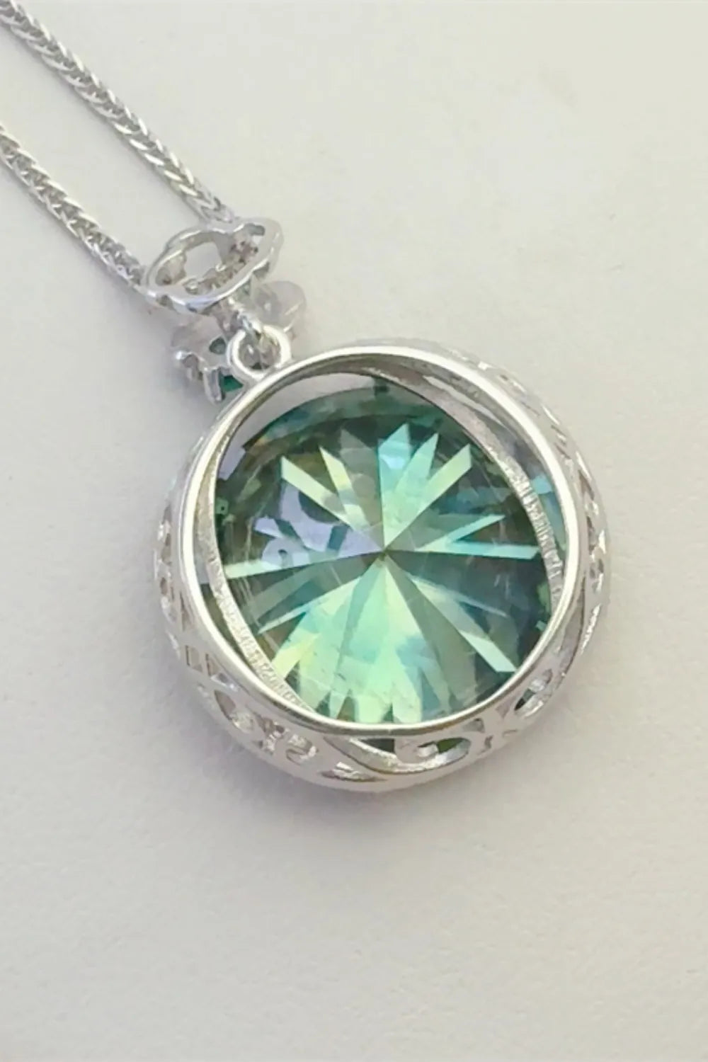 Dark green moissanite necklace in sterling silver with intricate filigree detail.