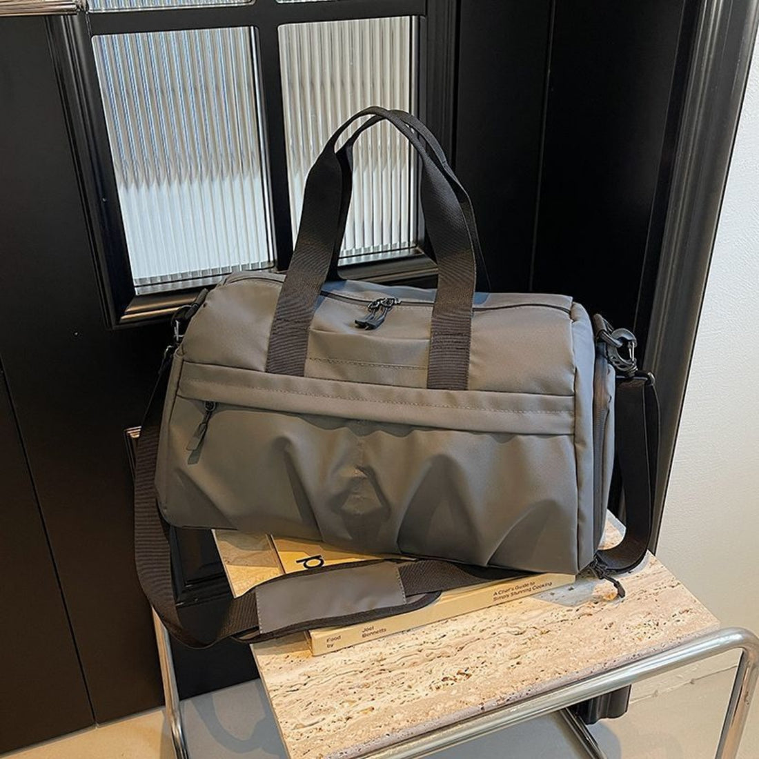 Gray nylon travel duffel bag with multiple zippered pockets and dual carry handles.