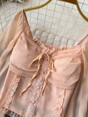 Romantic ruffled sleeve blouse in watermelon pink with a bow and pearl buttons.
