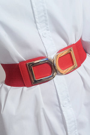 Red elastic belt with double gold buckle detail, cinching a white shirt.