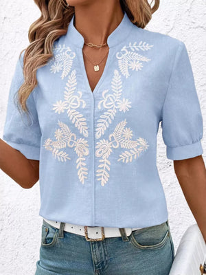 Blue embroidered notched blouse with cuffed sleeves and V-neck.