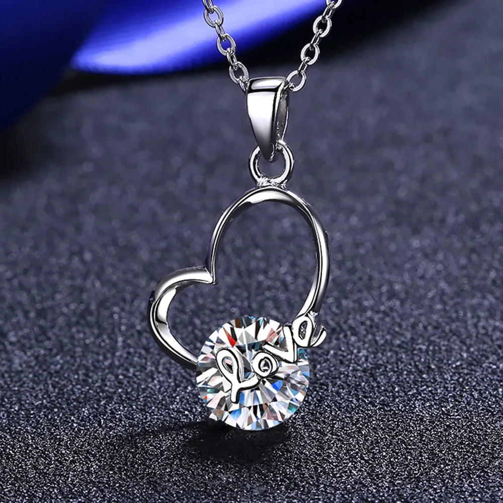 Silver heart halo pendant necklace with a round clear crystal and the word "love" inscribed.
