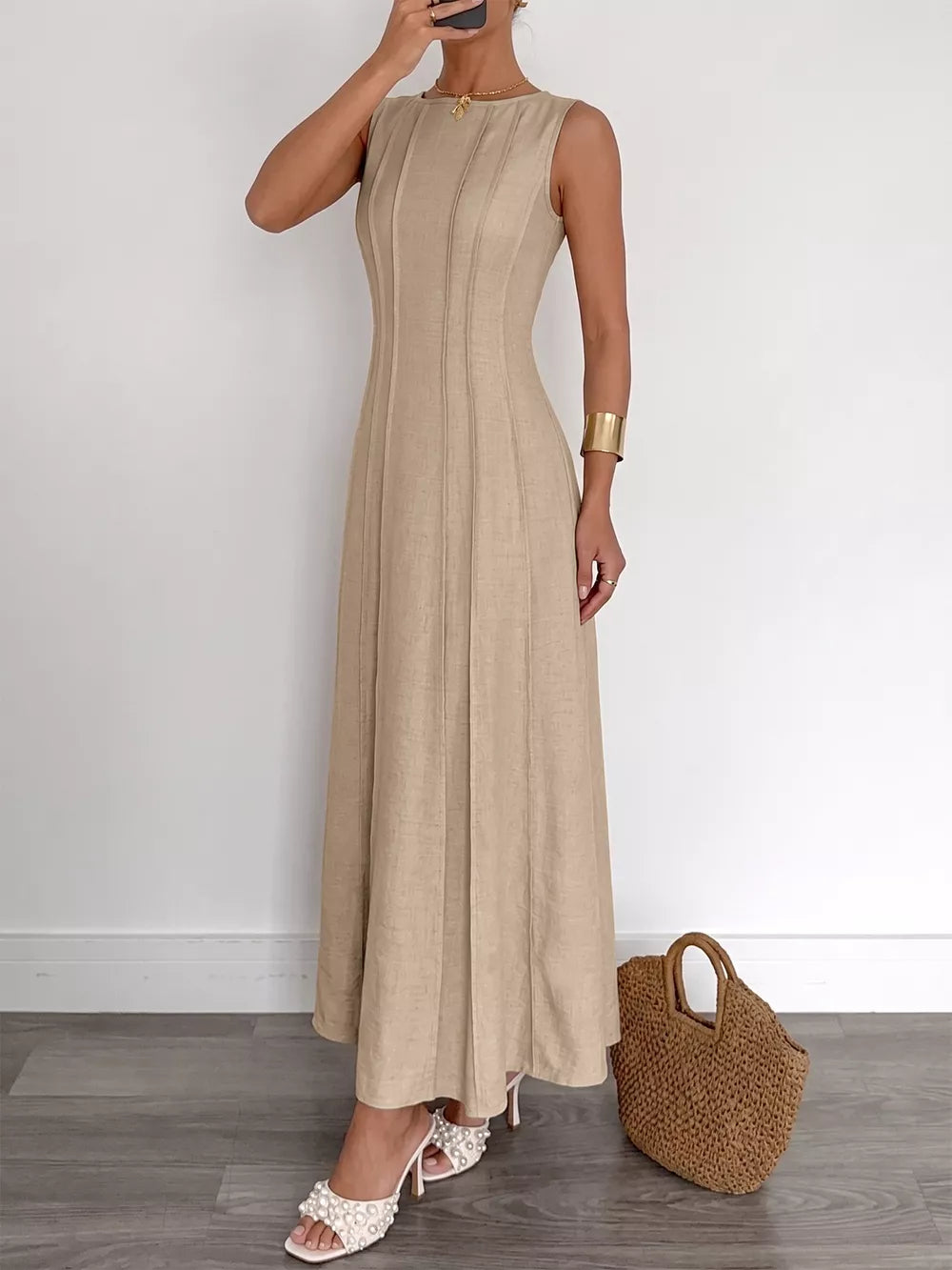Beige textured maxi dress with elegant silhouette, sleeveless, round neck, and vertical seam details.