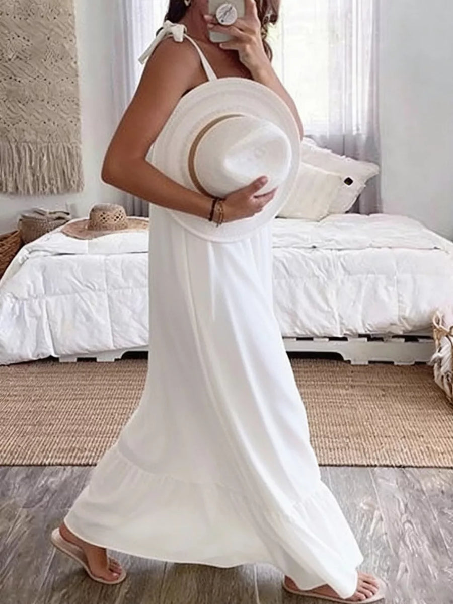 White tie strap maxi dress with tiered hem, styled with a wide-brim hat.