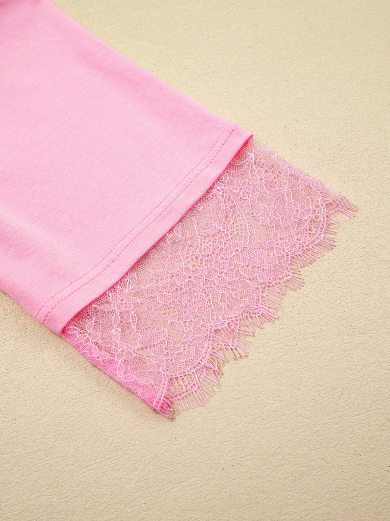 Pink cotton blend oversized tee with floral lace trim detail on the sleeve.