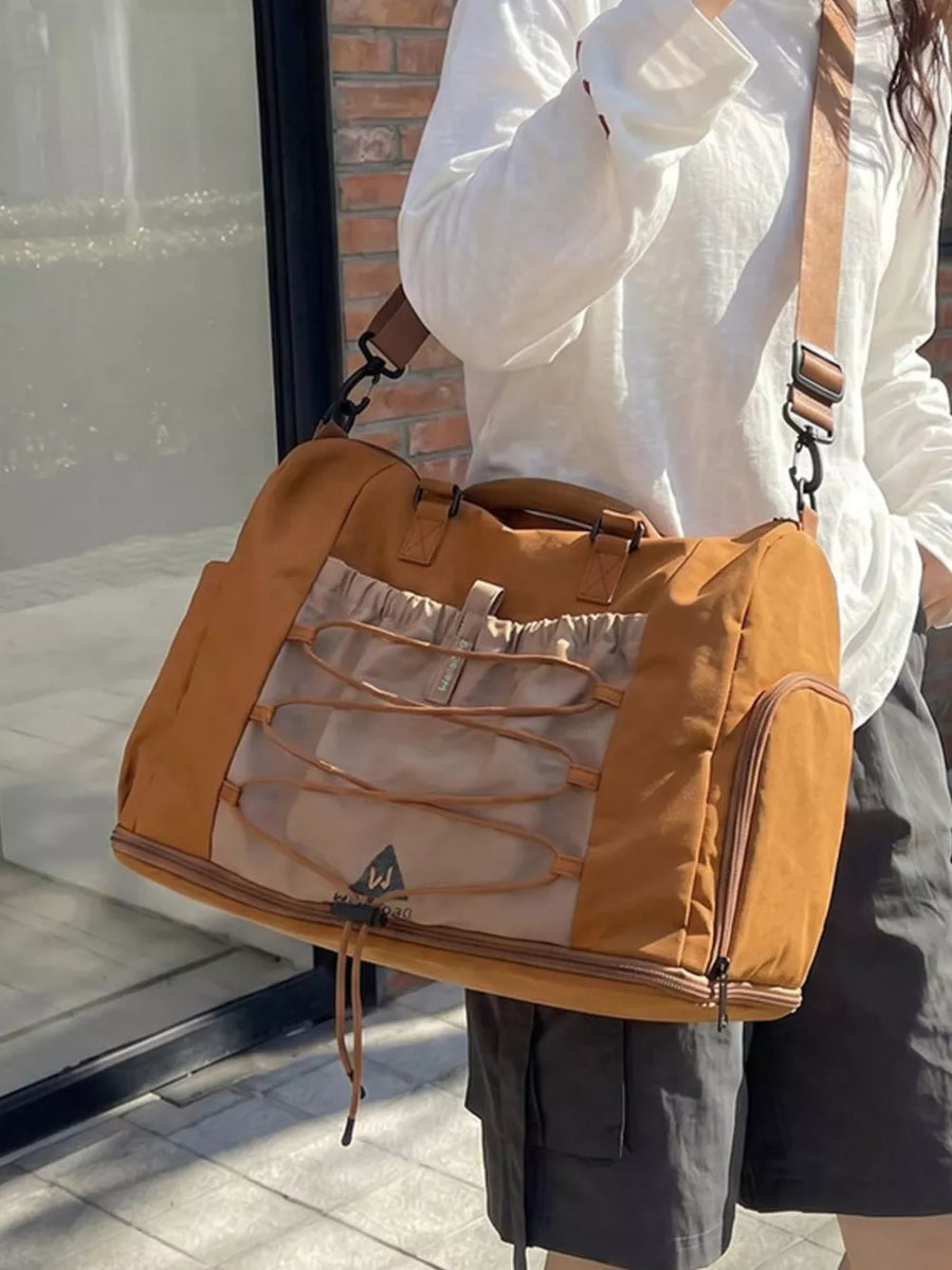 Beige and tan nylon duffel bag with bungee cord detail and side pockets.