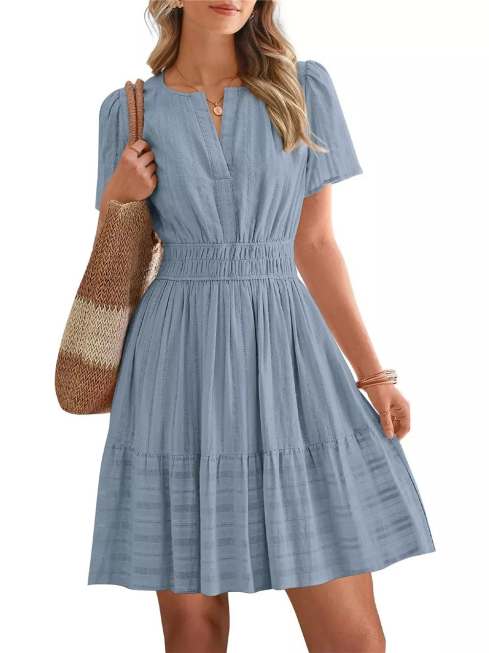 Textured light blue V-neck tiered dress with smocked waist and short sleeves.