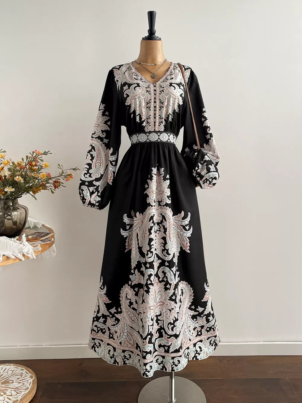 Black maxi dress with V-neck, balloon sleeves, and ornate paisley print.
