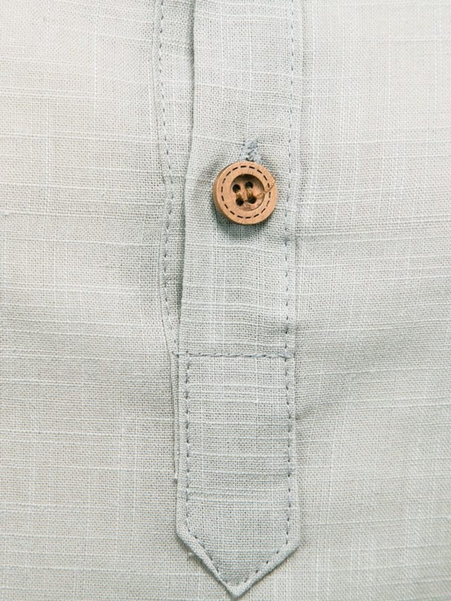 Light blue linen blend shirt with a single wooden button and placket detail