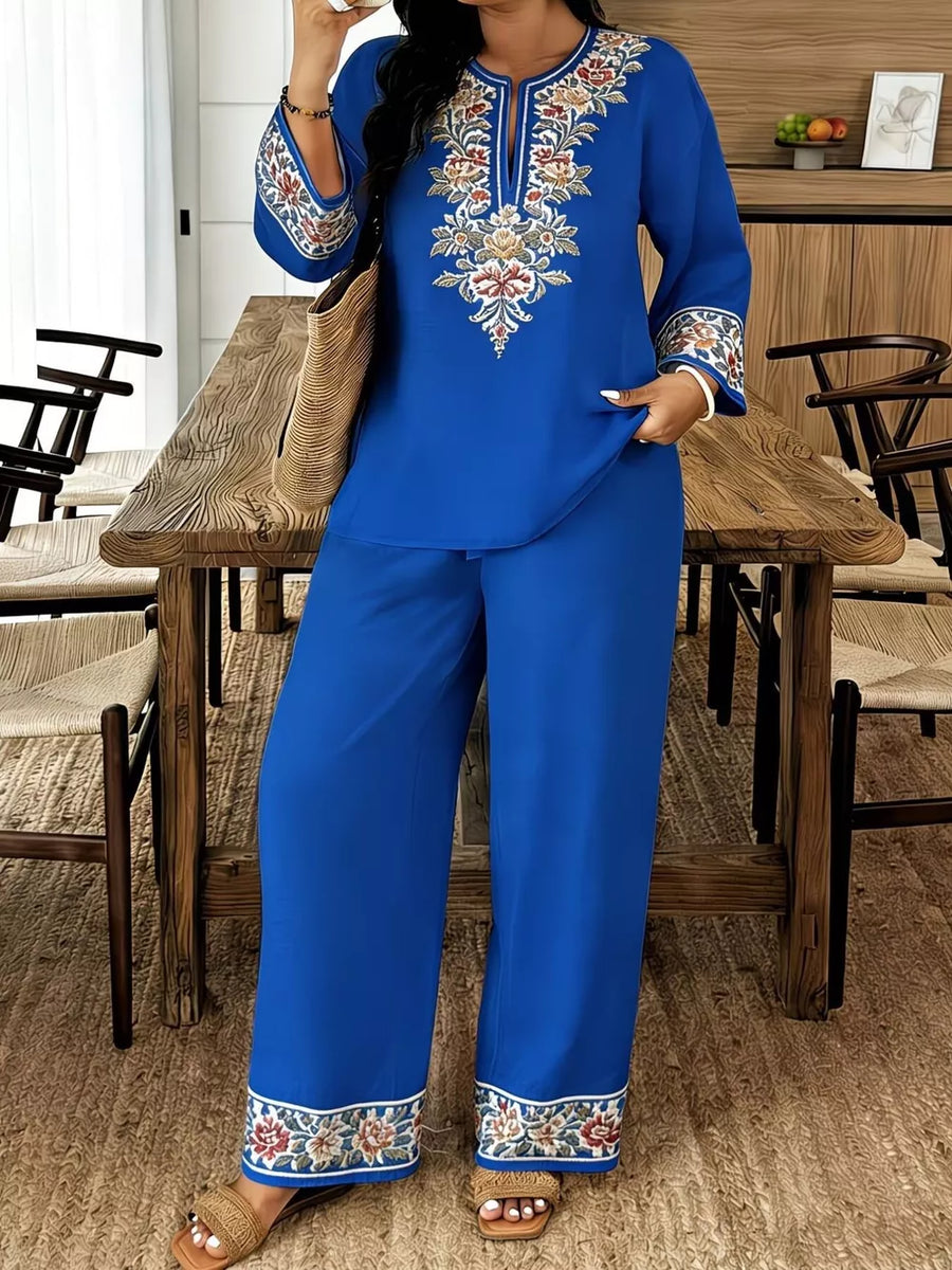 Blue embroidered peasant top with wide-leg pants, floral trim, and bell sleeves.