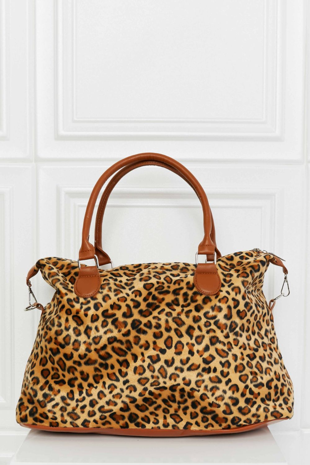 Leopard print travel satchel with brown leatherette trim and handles.