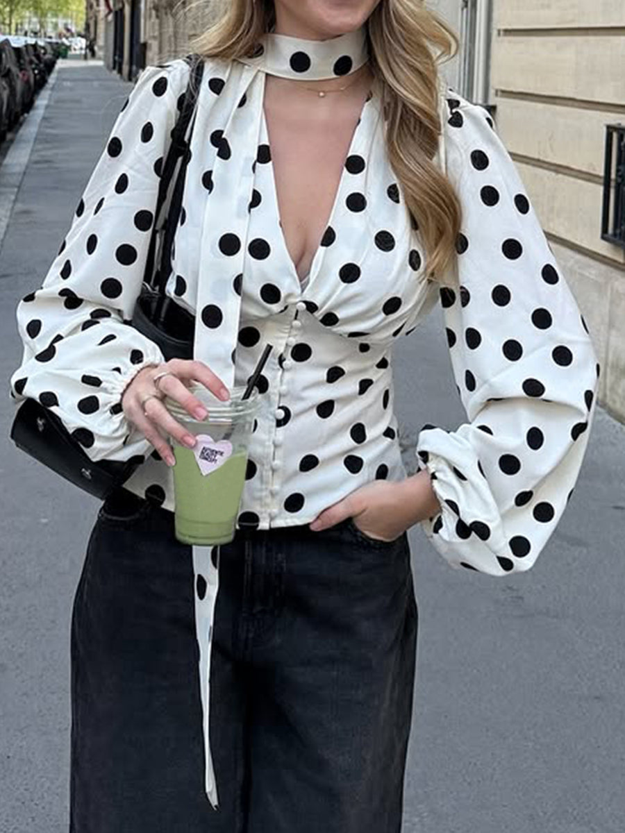 black blouse featuring buttoned and polka dot