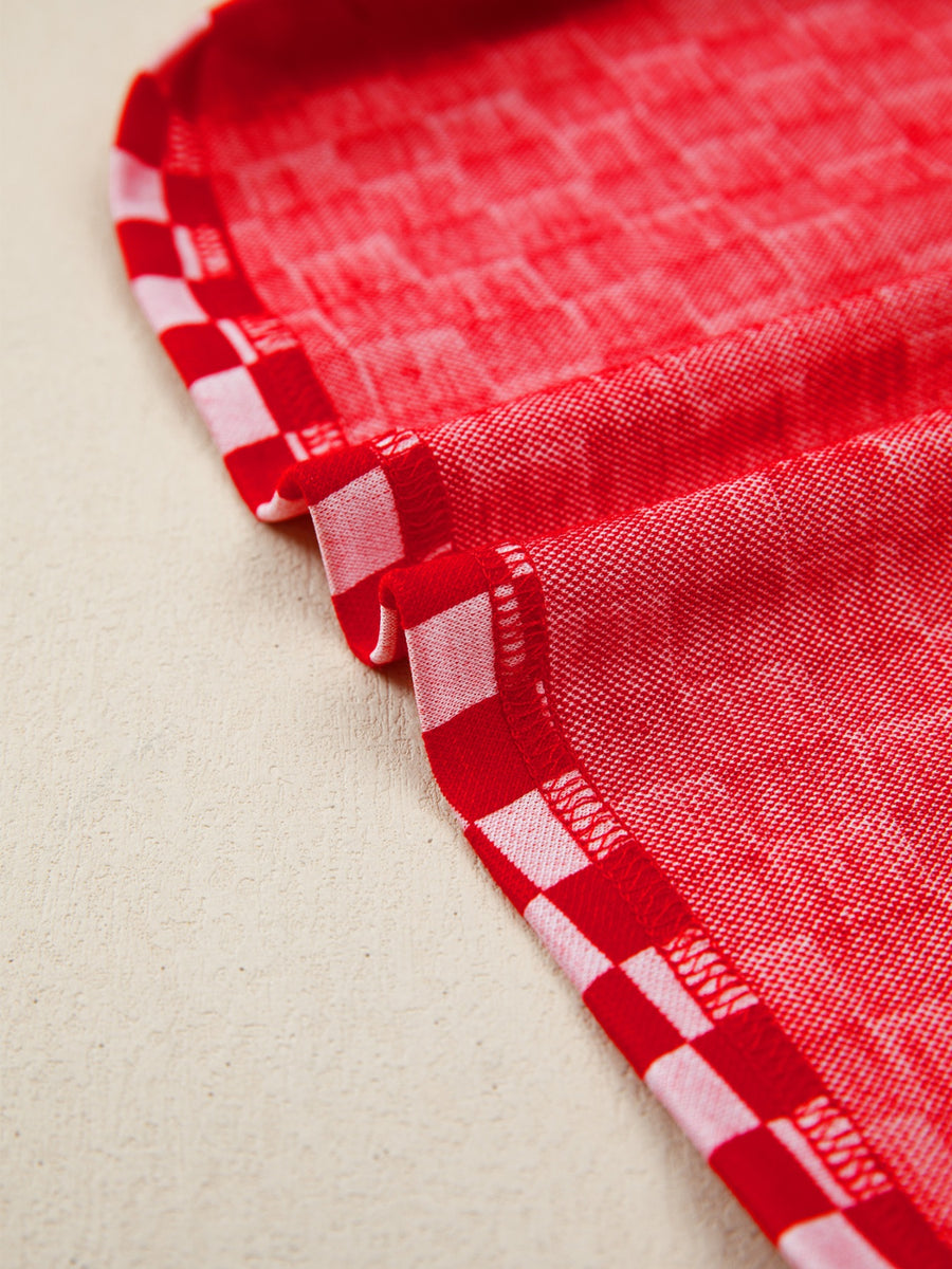 Red and white checkered print shirt with ruffle sleeve detail.