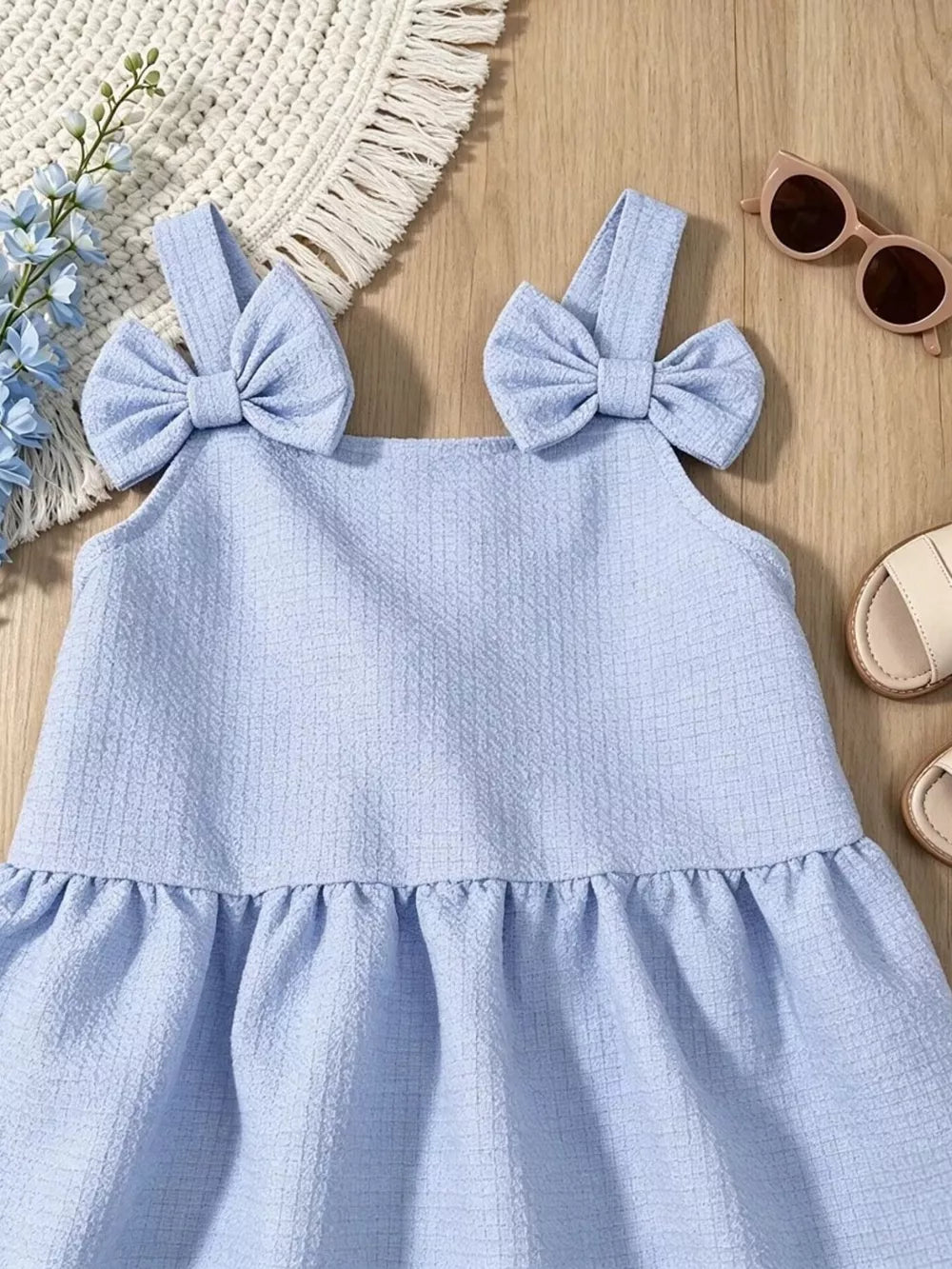 Sky blue baby dress with bow straps and ruffled hem