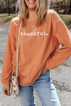 Orange corduroy pullover sweatshirt with white "thankful" graphic and relaxed fit.
