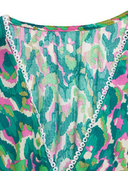 Vibrant V-neck maxi dress with abstract print and white trim detail.