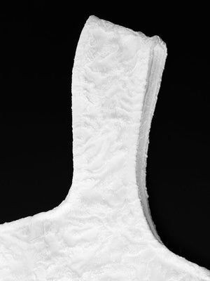 Textured white square neck mini dress detail showing fabric texture and neckline.