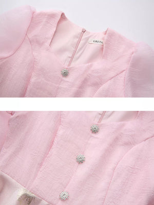 Pink midi dress with puff sleeves, square neckline, and jeweled buttons.