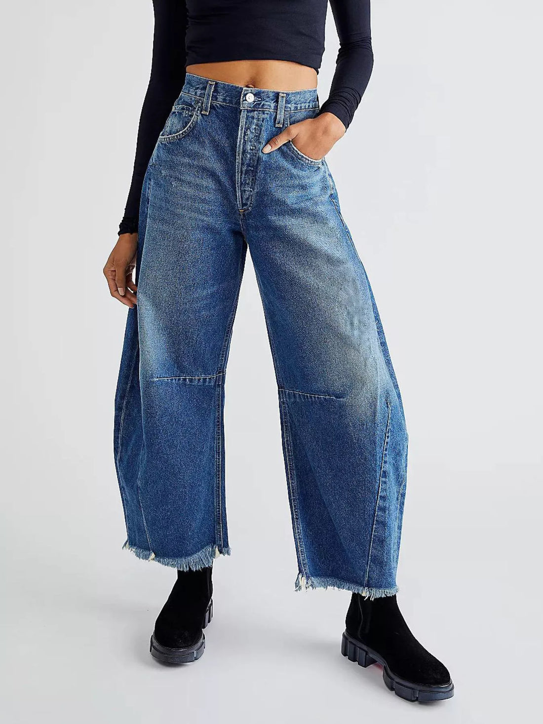 Blue denim wide-leg trousers with raw hem and panel details.