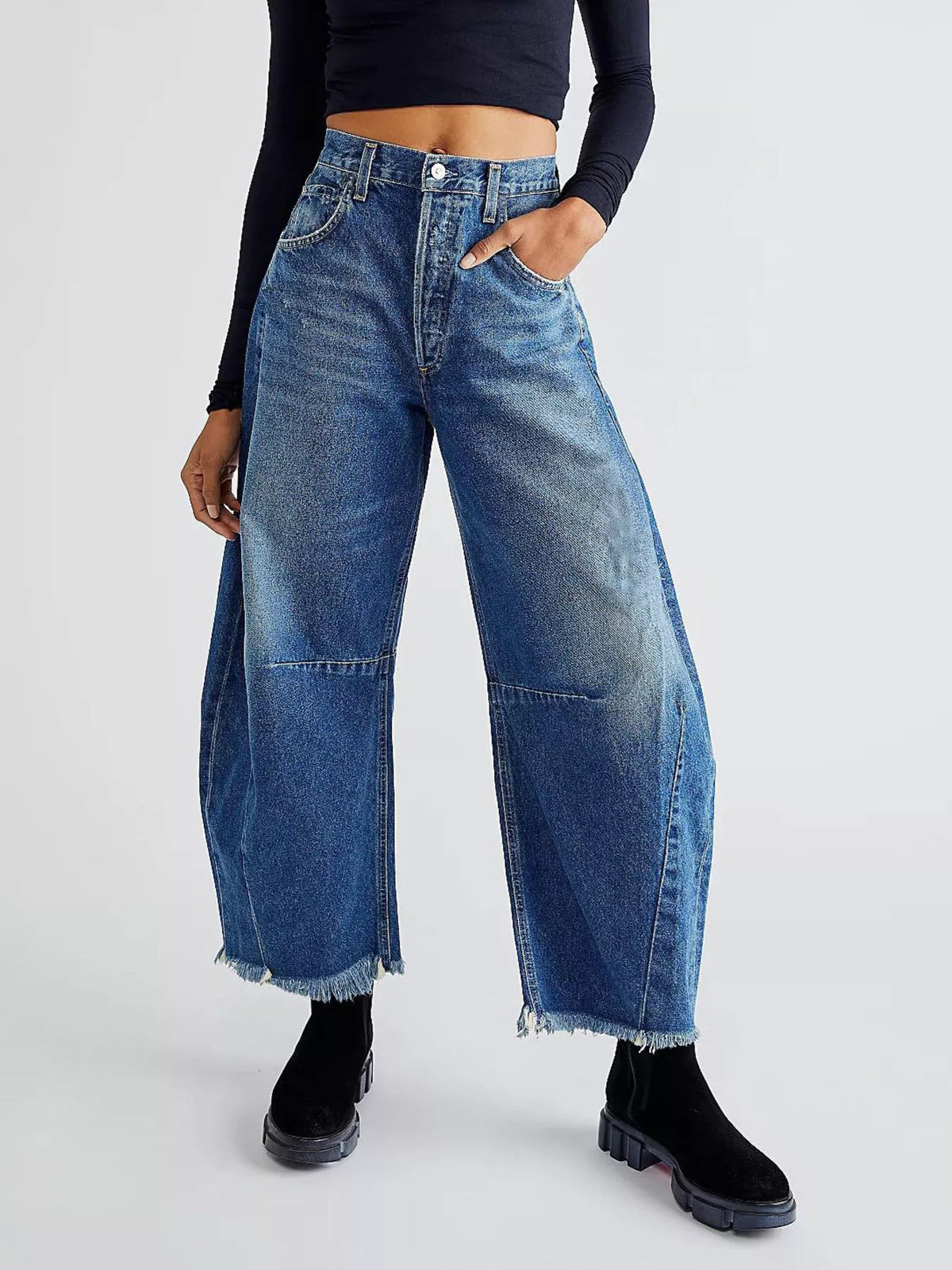 Blue denim wide-leg trousers with raw hem and panel details.