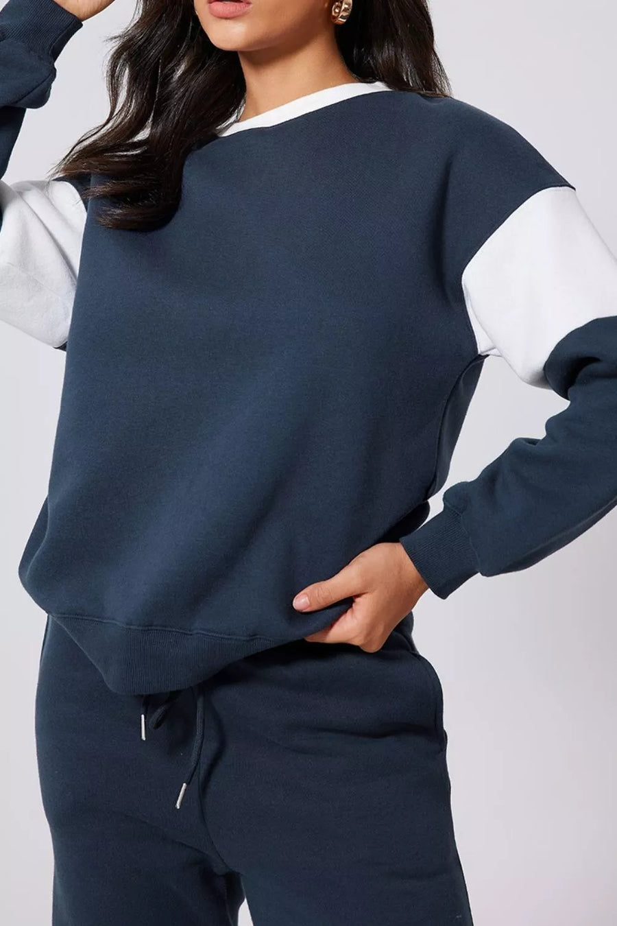 Navy oversized sweatshirt with white colorblock sleeves and crew neck, paired with matching sweatpants.