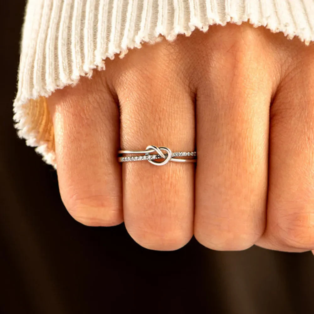 Pavé knot sterling silver ring with two bands, one plain and one with small stones.