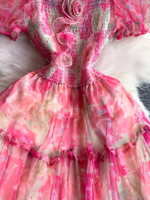 Floral tiered midi dress in pink with smocked bodice and ruffled details.