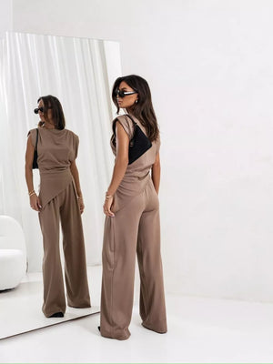 Tan satin cowl neck two-piece set with asymmetrical wrap skirt detail and wide leg pants.