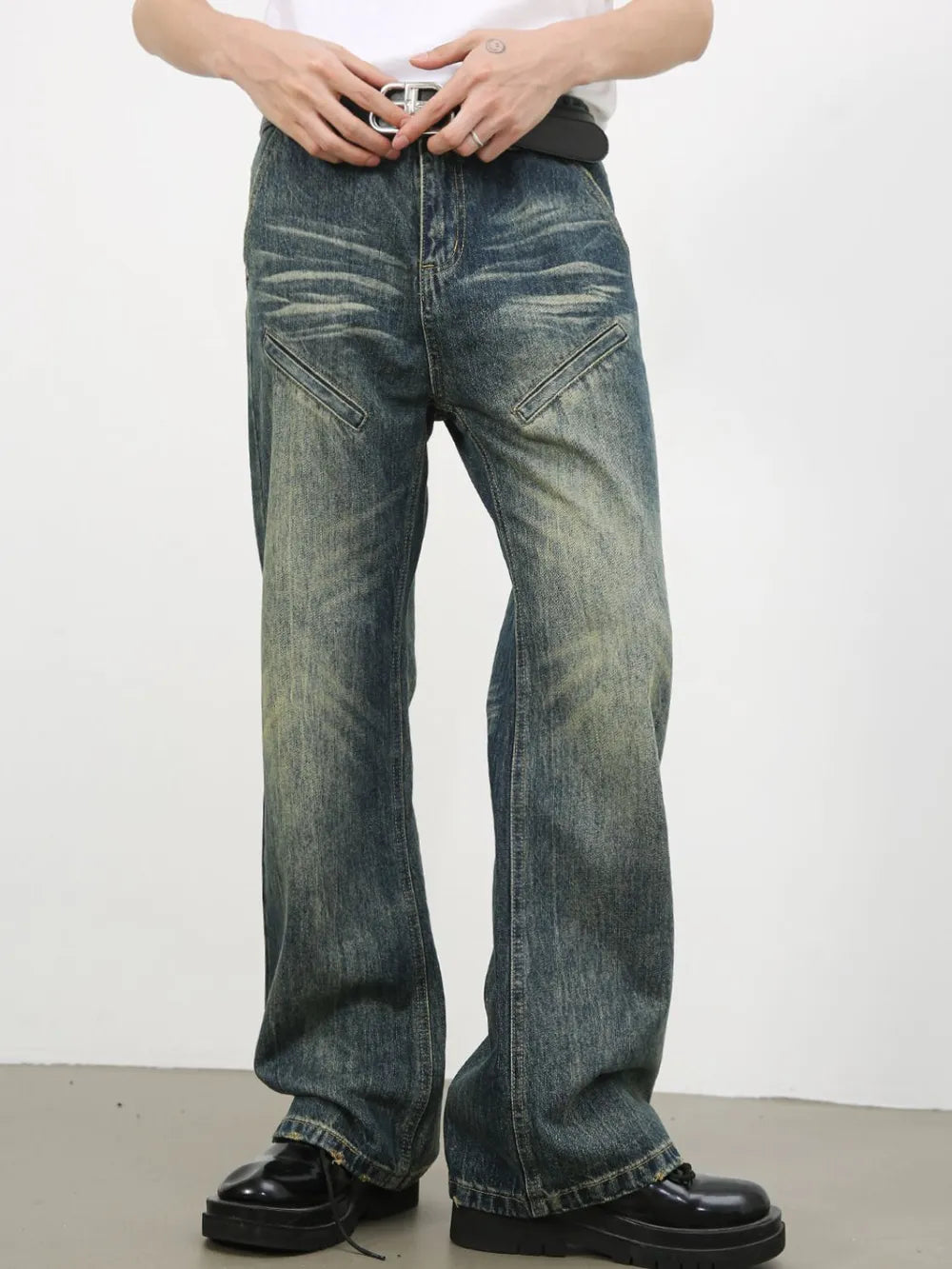 Vintage wash flare leg jeans in medium blue denim with distressed details and angled front pockets.