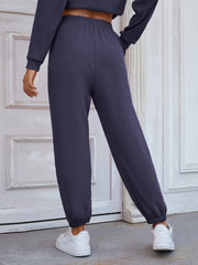 Dark blue cuffed joggers with an elastic waistband and relaxed fit.