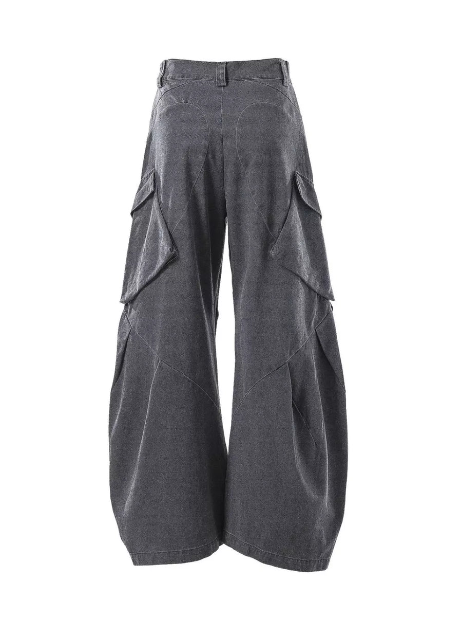Dark gray textured paneled cargo pants with multiple flap pockets and a baggy fit.