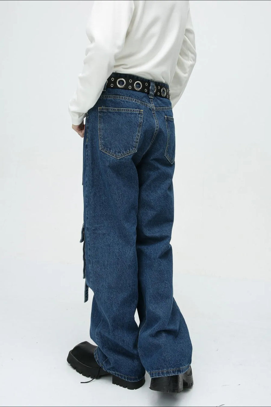 Medium wash denim cargo pants with buckle strap details and a wide leg cut.