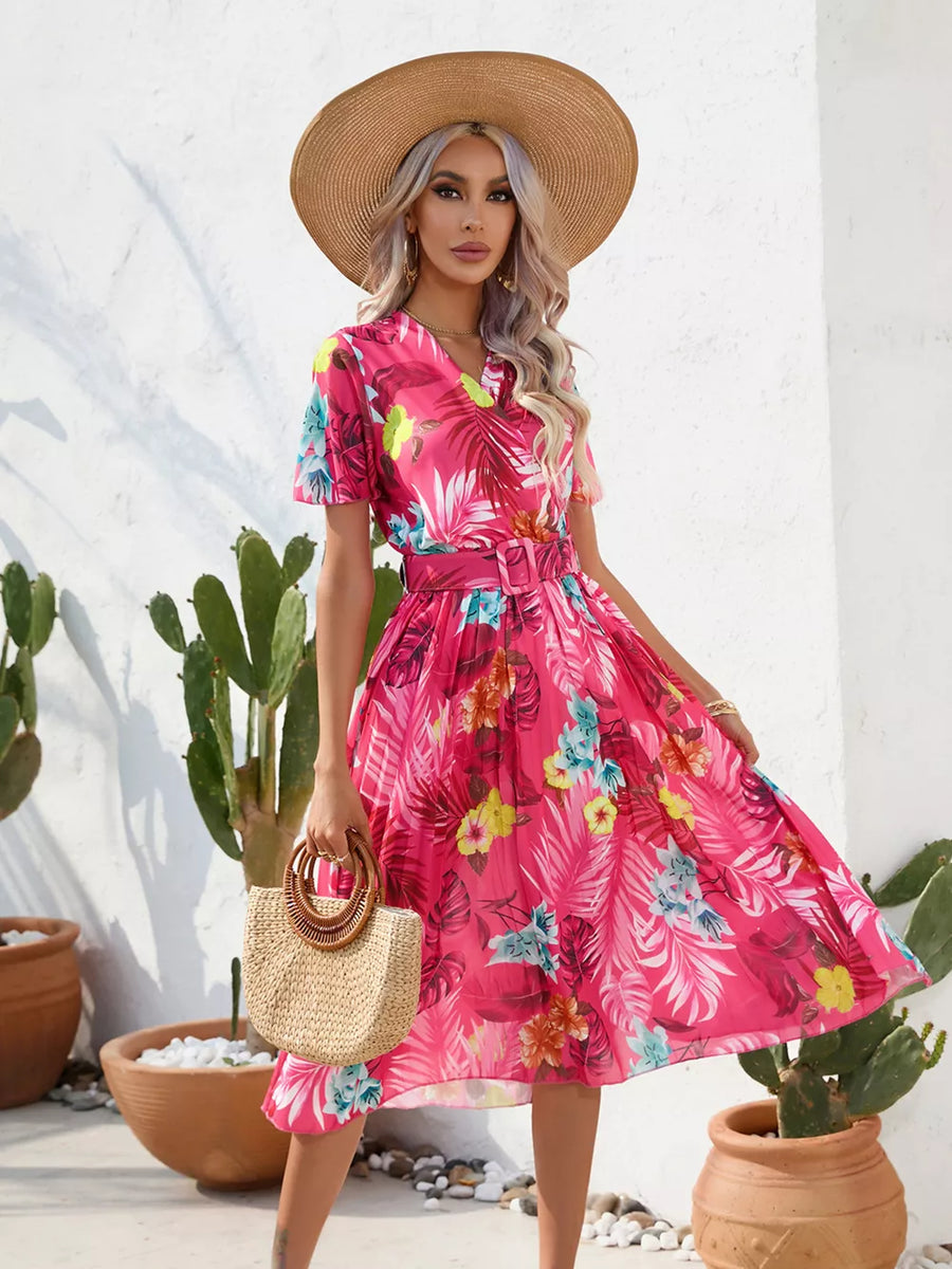 Hot pink tropical pleated midi dress with belt and short sleeves.
