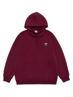 Maroon quarter-zip hoodie with a front pouch pocket and a small embroidered patch.