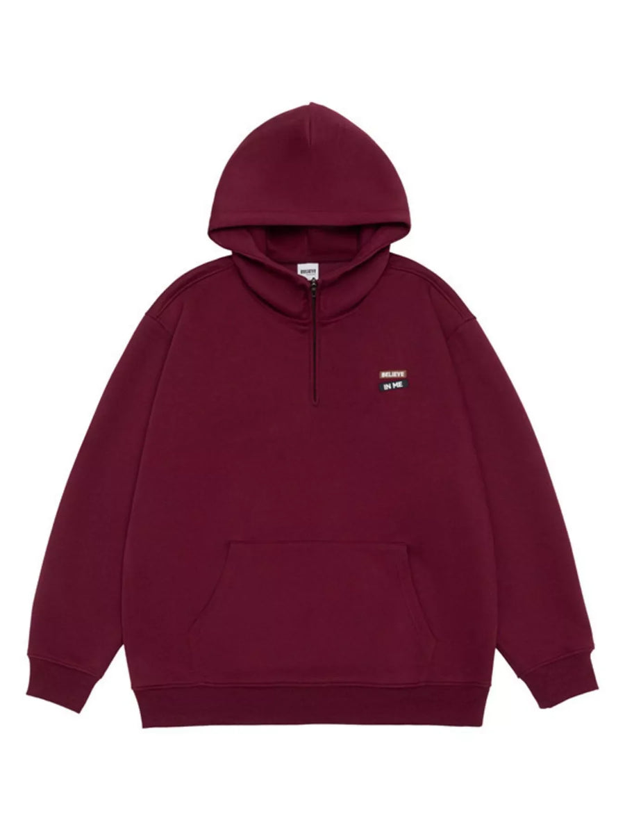 Maroon quarter-zip hoodie with a front pouch pocket and a small embroidered patch.