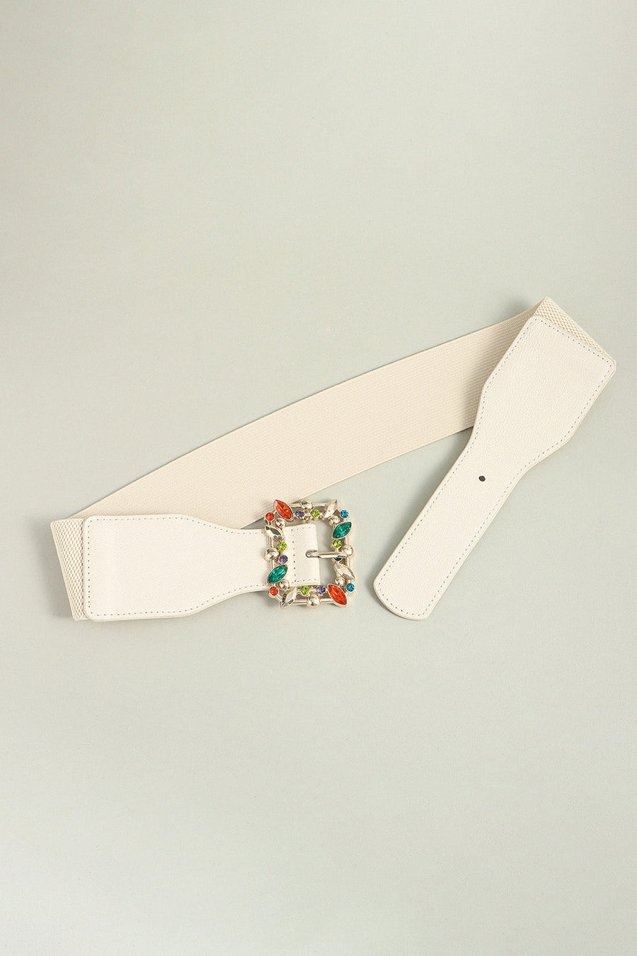 Ivory elasticated belt with jeweled buckle and faux leather trim.