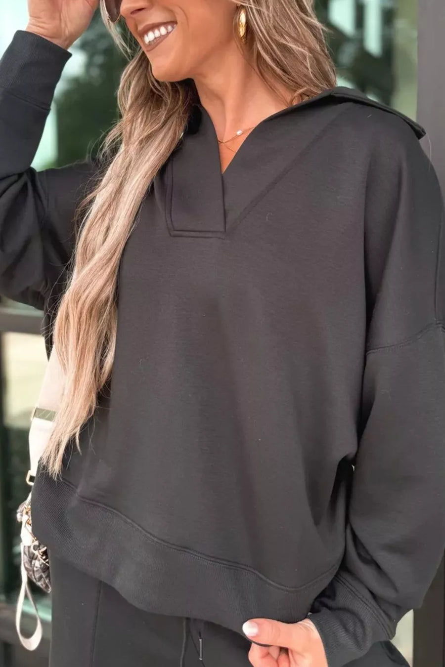 Black collared V-neck sweatshirt with ribbed cuffs and hem, part of a pajama set.