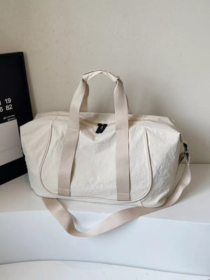 Cream white lightweight oxford cloth duffel bag with dual handles and adjustable shoulder strap.