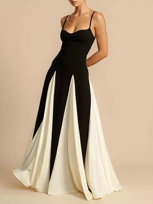 Elegant black and white maxi dress with spaghetti straps and a flowing skirt.