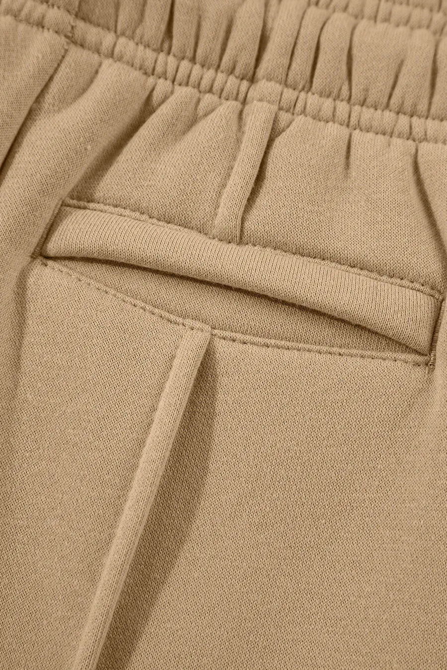 Tan sweatpants with elastic waistband and seam detail pocket