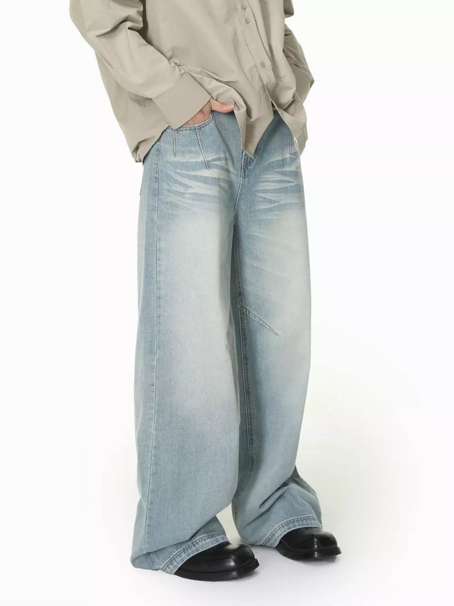 Men's light wash wide-leg jeans with vintage fading and a relaxed fit.